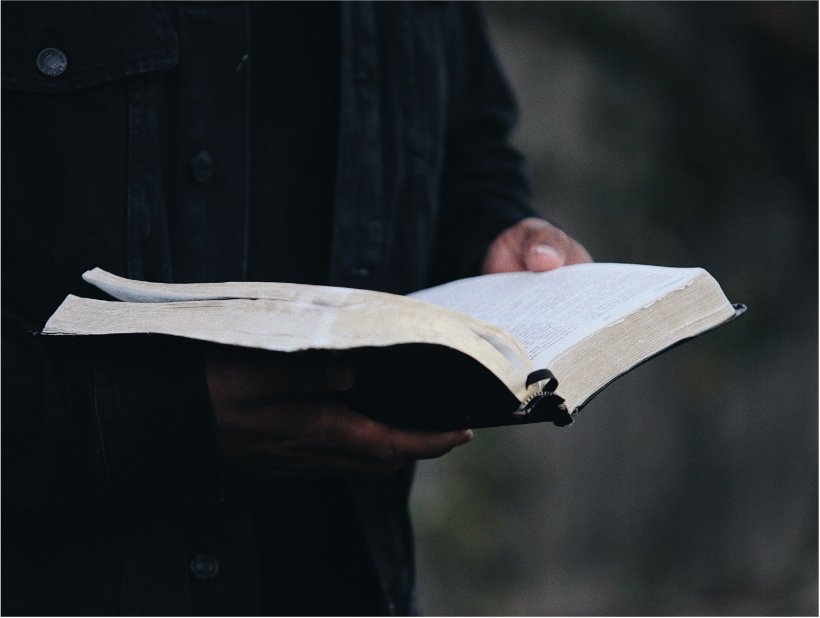 A man holding and reading the Holy Bible